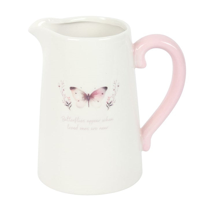 Decorative white butterfly jug displayed on a shelf with dried flowers