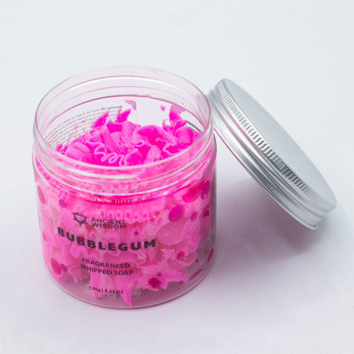 Pink whipped soap in a jar with a silver lid on a white background